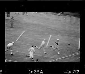 Football players running towards missed ball on ground