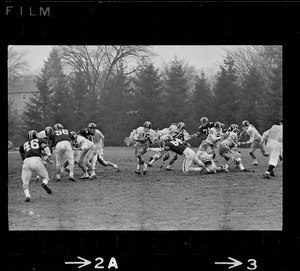 Football player with ball breaking away from defense