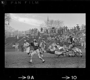 Football game and spectators in bleachers in rain