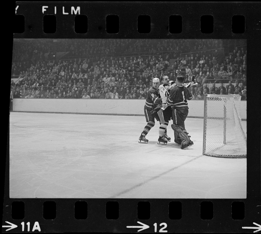 Boston Bruins player, Albert Langlois (no. 14), arguing with Toronto Maple Leaf goalie, Johnny Bower (no. 1)
