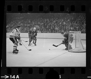 Toronto Maple Leafs goalie, Johnny Bower (no. 1)., blocking puck in game against the Boston Bruins
