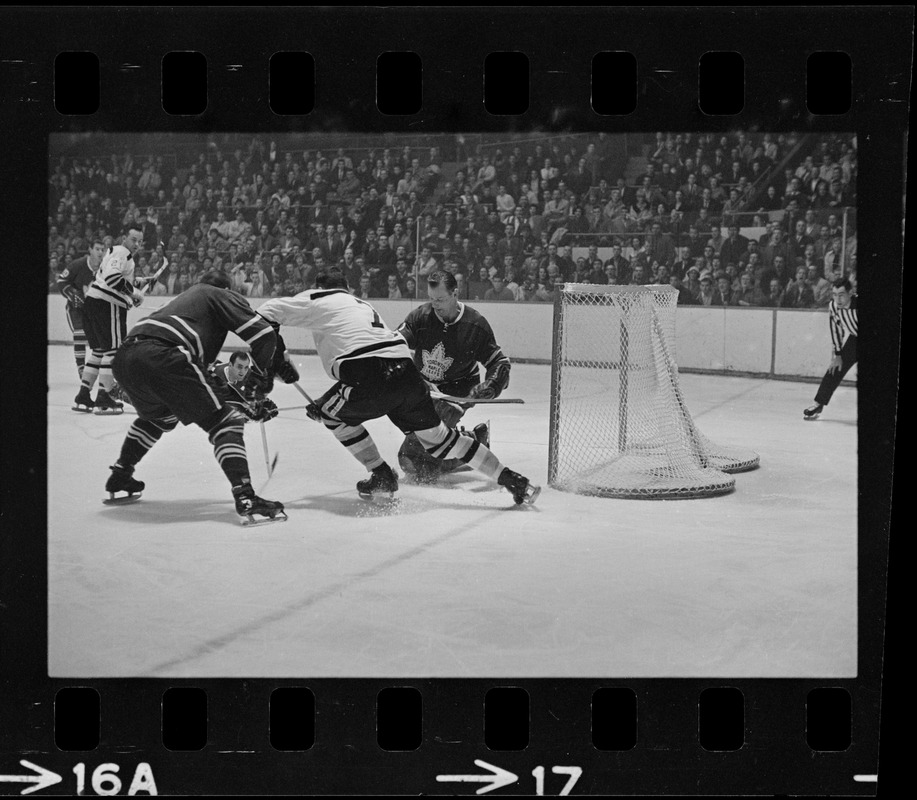 Toronto Maple Leafs goalie, Johnny Bower (no. 1), blocking puck in game against the Boston Bruins