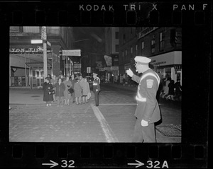Police officer directing traffic and pedestrians at an intersection during Boston blackout