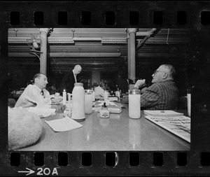 Two men talking across desks during Boston blackout