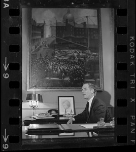 Mayor of Boston Kevin White sitting at desk with a large painting above
