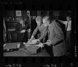 Secretary of State Kevin White, left, Senator John F. Parker, center, and attorney Lewis F. Rubin, right, review documents to authorize Rubin to accept in Joseph Fernandes name the chance to run on GOP state ticket