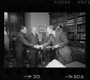 Secretary of State Kevin White, far right, shakes hands with Paul M. Siskind, Dean of Boston University Law School, at swearing ceremony for special board for Bellotti hearing