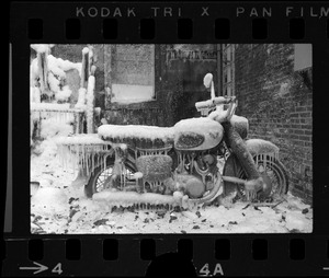 Motorbike covered in ice in the ruins of a fire in the North End