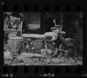 Motorbike covered in ice in the ruins of a fire in the North End