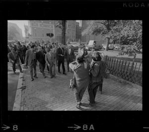 Reporters film a group of mayors of big cities while they take a tour of Boston's Back Bay neighborhood