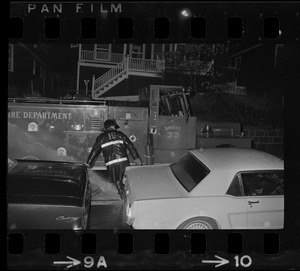 Firefighter between cars and a fire truck