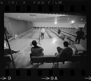 Mayor Kevin White bowling with Boston Police bowling team watching in the foreground at Lucky Strike Alley