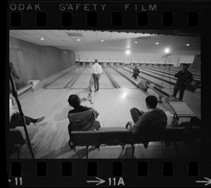 Mayor Kevin White bowling with Boston Police bowling team watching in the foreground at Lucky Strike Alley