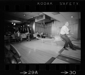 Mayor Kevin White bowling with Boston Police bowling team watching in the back at Lucky Strike Alley