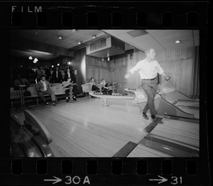 Mayor Kevin White bowling with Boston Police bowling team watching in the back at Lucky Strike Alley