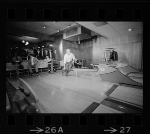 Mayor Kevin White bowling with Boston Police bowling team watching in the back at Lucky Strike Alley