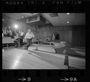 Mayor Kevin White bowling with Boston Police bowling team watching in the back at Lucky Strike Alley