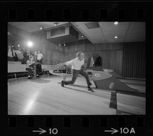 Mayor Kevin White bowling with Boston Police bowling team watching in the back at Lucky Strike Alley