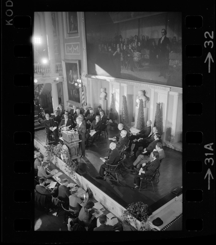 Mayor Kevin White speaking on stage at podium during his inauguration in the Great Hall at Faneuil Hall