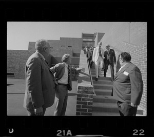 Boston Mayor Kevin White talking with group of men on stairs while on tour of new school