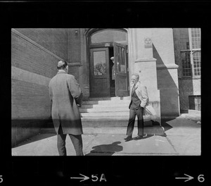 Boston Mayor Kevin White standing outside of doorway of English High School