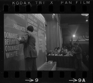 Man filling in election returns on tracking board at Kevin White's election night party at Bradford Hotel during primary race for governor of Massachusetts