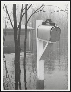 Mailbox with sign, "13 Kraz" in foreground, flooding in background
