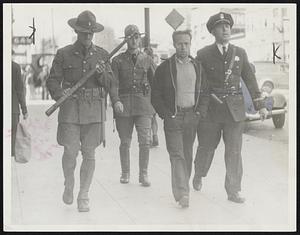 Francisco Calif. July 5. Photo shows an San Francisco striking longshoreman receiving the support of the police department and the state militia in the tedious walk to the city prison.