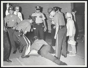 State cop wrestles with anti-draft demonstrator on sidewalk in Concord, Mass., outside draft board headquarters last night. Demonstrators had blocked doorway as draft board members left the building