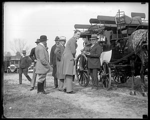 A group of unidentified men standing next to a stagecoach