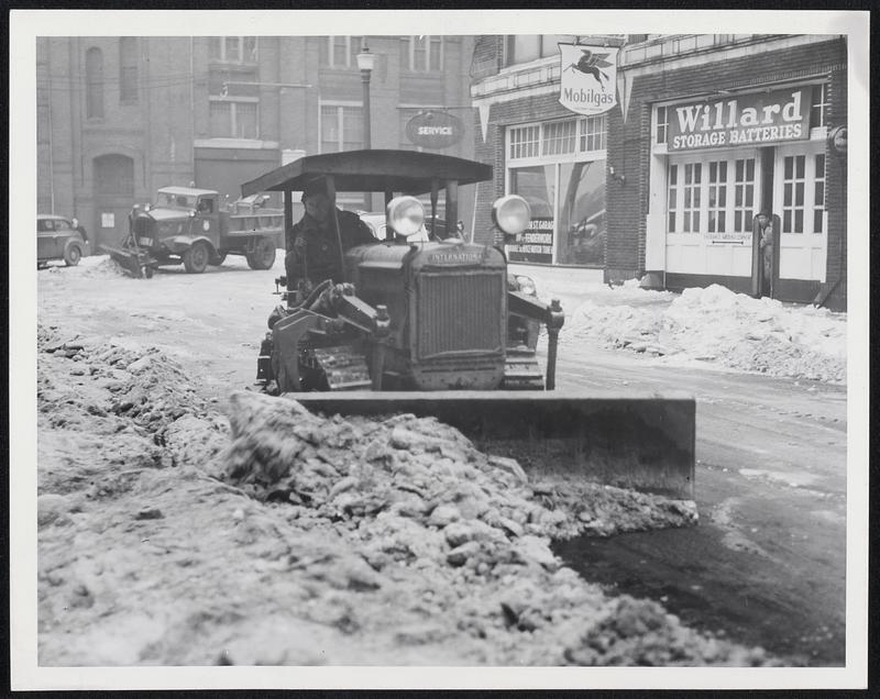 Bulldozer Scrapes Ice on Falmouth Street as the Boston Public Works Department yesterday began the task of clearing streets of ice and snow from last week's storm.