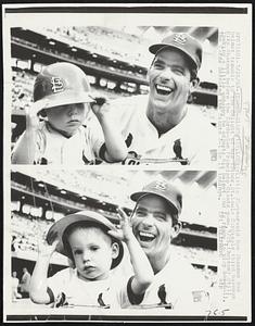 (Cards-Giants) St. Louis: Little 2 1/2-year-old Dan Shannon has helmet trouble to the delight of his father, St. Louis Cardinals third baseman Mike Shannon before the Cards-San Francisco Giants game, 7/25. (Bottom) Still looking a little unhappy he adjusts his helmet and is ready to play baseball. The Cards defeated the Giants 2-1 in 13 innings