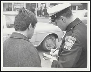 Caught Jay-walking Alfred Handara of Winthrop waits for his ticket at Stuart st. +Washington st.