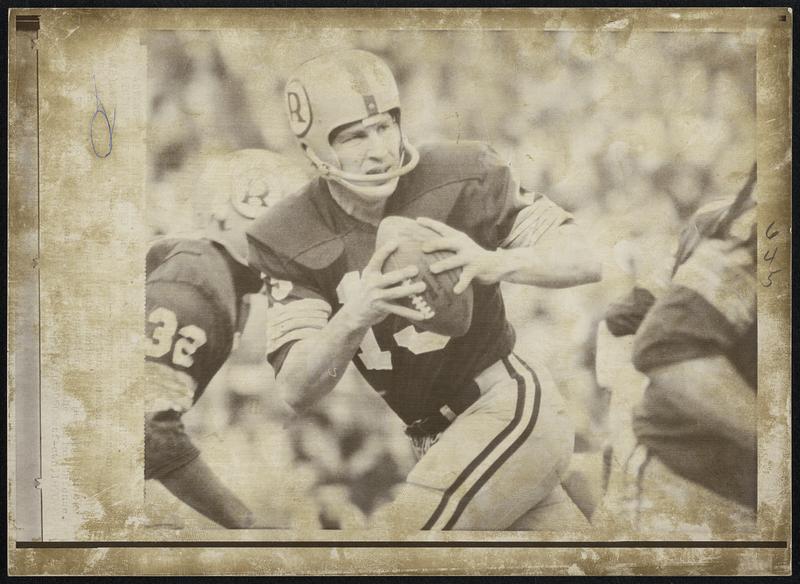 Frank Ryan holds a football in his hands during a play