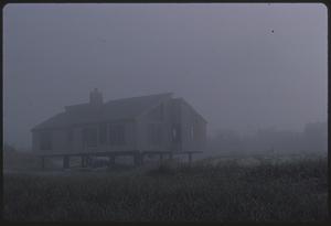 Beach house on pilings in fog