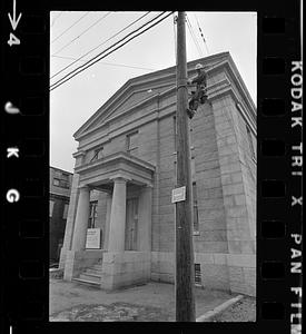 Man climbing pole near Customs House