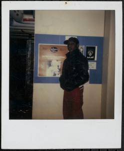 Young man posing in front of a poster