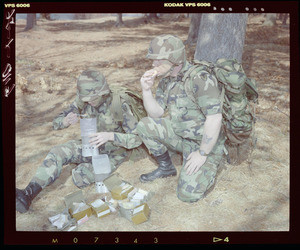 Food lab, 2 G.I. eating ration in woods