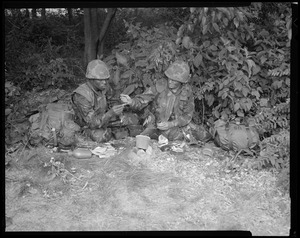 Food lab, new meal, ready to eat, out in field with G.I. putting sauce on hot dog