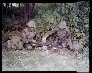 Food lab, new meal, ready to eat, out in field with G.I. pouring water in canteen, opening food pack