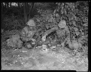 Food lab, new meal, ready to eat, out in field with G.I. pouring water in canteen, opening food pack