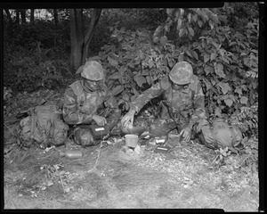 Food lab, new meal, ready to eat, out in field with G.I. pouring water in canteen, opening food pack