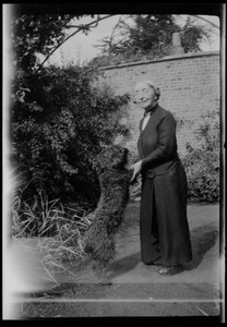 Miss Gleeson with Una the "Kerry blue" in the garden of Dun Emer, Dublin