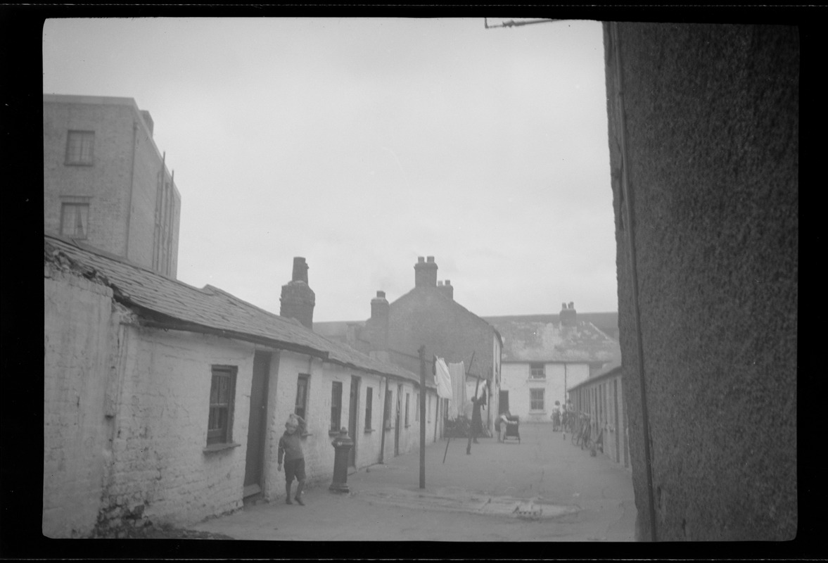 Alley next to the St. Ultan's new apartment houses showing housing conditions not yet corrected