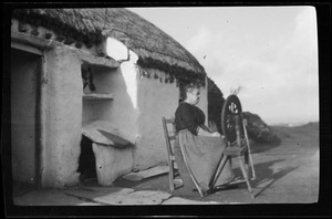 Woman spinning yarn outside Mrs. Harry Duggan's house, Gortahork, Co. Donega
