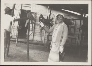 Port-of-Spain, Trinidad, B. W. I., E. O'C. holding the parrot in the East Indian village