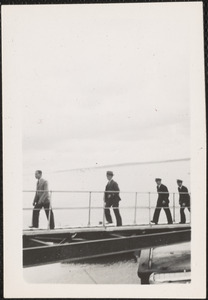 Four men embarking or disembarking ship or airplane