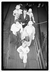 People walking up a gangplank onto a ship
