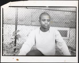 Two boys by a metal fence