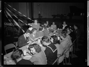 Youth and servicemen sitting at table